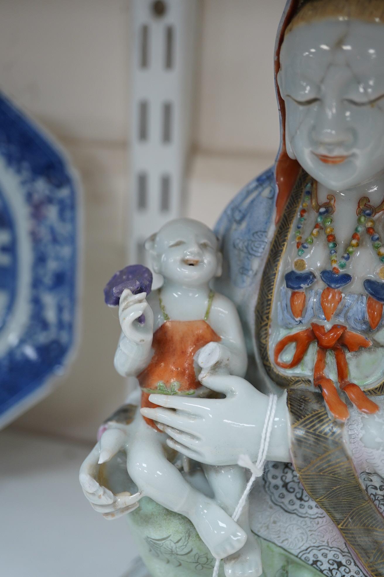 A Chinese enamelled porcelain group of Guanyin holding a child, Qianlong period